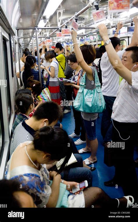 inside subway tube train carriage compartment with chinese commuters commuter passengers