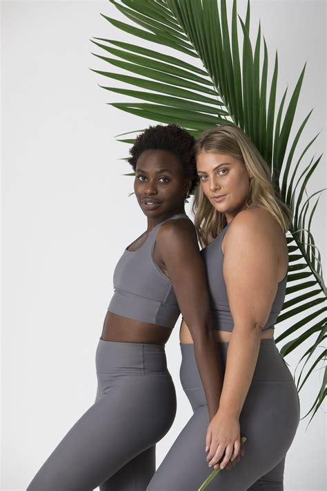 two women standing next to each other in grey sports bra tops and leggings