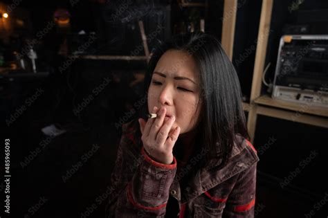 Asian Girl Smoking A Weed Joint Getting High Inhaling And Exhaling Weed Smoke Stock Photo