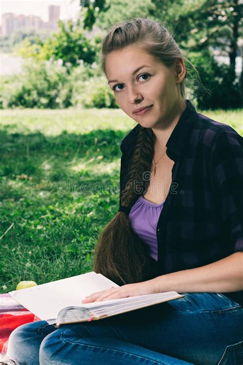 Pretty Blond Teenager Sitting In The Grass Stock Image
