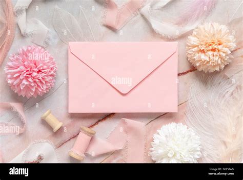 Pink Envelope Between Pastel Flowers Silk Ribbons And Feathers On