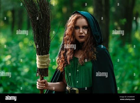 Young Witch With Broom In Green Forest Stock Photo Alamy