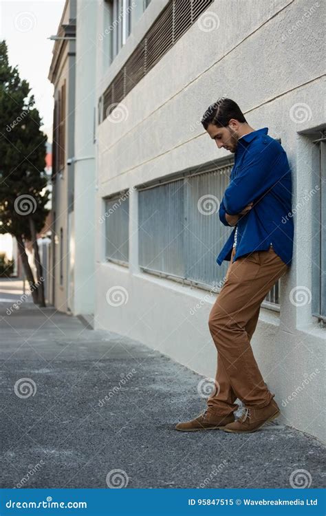 Man Looking Down While Leaning On Wall Stock Image Image Of Arms