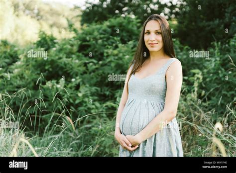 Pregnant Brunette Woman In The Park Stock Photo Alamy