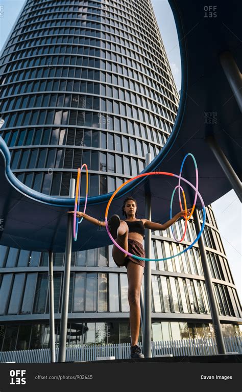 Generation Z Woman Performing Hula Hoop Dance With Rings In Downtown