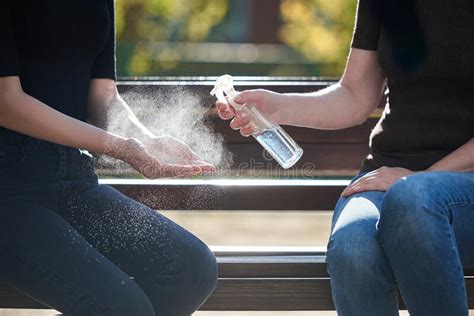 Women`s Hands Are Treated With A Sanitizer Girl`s Hands Against The Background Of A Bench