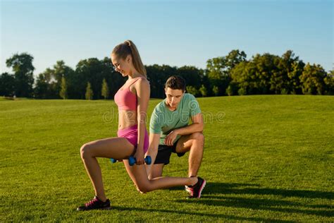 Тренер приниманнсяый за фитнес с девушкой на природе Стоковое Изображение изображение