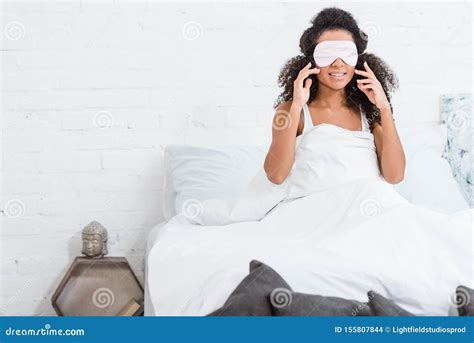 African American Girl With Eyes Covered By Sleeping Blindfold In Bed
