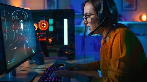 Pretty And Excited Gamer Girl In Glasses And Headset With A Mic Playing