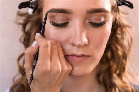 The Makeup Artist Paints The Eyebrow Of The Model Using A Pencil Stock