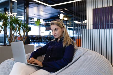 Caucasian Woman Using A Laptop In A Bean Bag Stock Photo Image Of