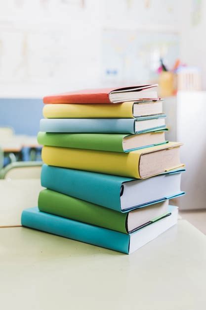 Os livros escolares representam uma grande despesa e um peso no orçamento familiar. Livros escolares coloridos arranjados na mesa | Foto Premium