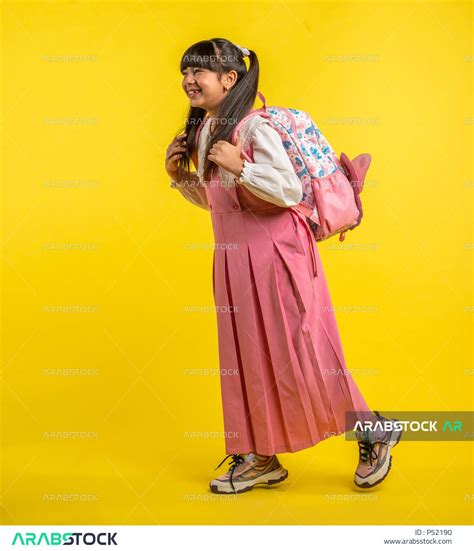 بورتريه لطالبة عربية خليجية سعودية، ترتدي الزي المدرسي، تحمل الحقيبة المدرسية، إيماءات تدل على
