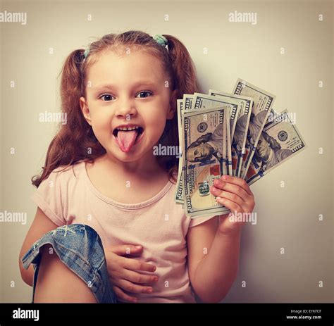 Funny Small Kid Girl Holding Money And Showing The Tongue Vintage Closeup Portrait Stock Photo