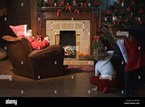 Children Watching Santa Claus In Living Room Stock Photo Alamy