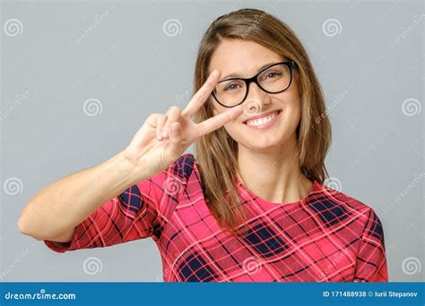 Cheerful Woman Showing Peace Sign With Her Fingers Stock Photo Image