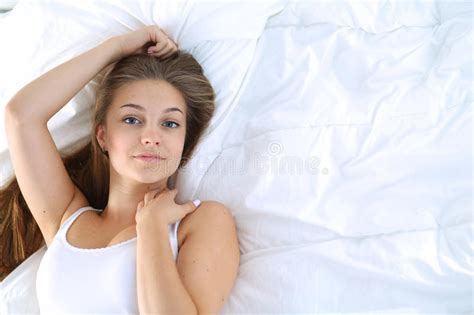 A Beautiful Young Woman Lying In Bed Comfortably And Blissfully Stock