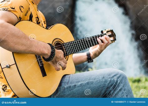 Closeup Shot Of A Young Man Playing The Guitar Outdoors In A Natural