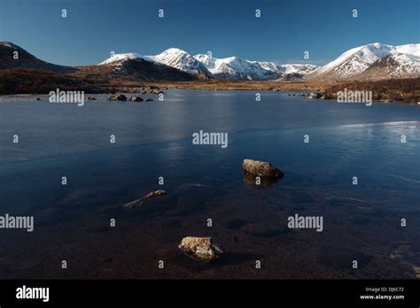 Snowcapped Mountains And Frozen Loch In Scottish Highland Scenery Stock