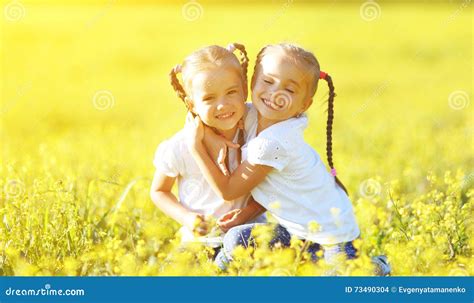 Happy Children Twins Sisters Embracing In Summer On Nature Stock Photo