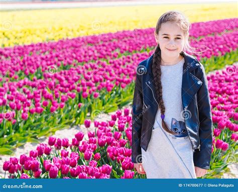 Cute Teen Girl With Long Hair Smelling Tulip Flower On Tulip Fields In Amsterdam Region Holland
