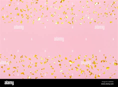 Horizontal Frame Of Golden Glitter Confetti Sparkles On Pastel Pink