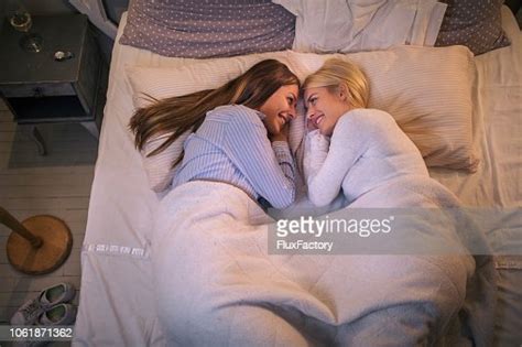 Lovely Lesbian Girlfriends Smiling While Lying In Bed Together High Res