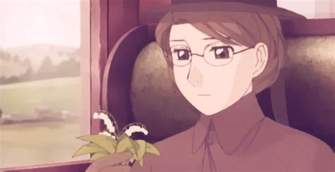 A Man With Glasses And A Hat Holding A Flower In Front Of A Train Window