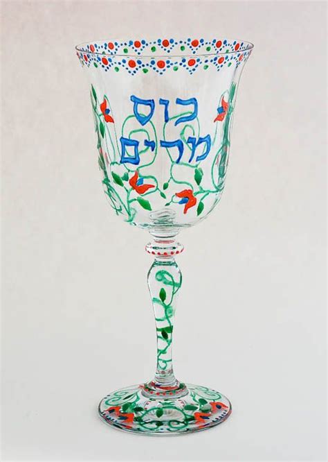 A Glass With An Ornate Design On The Rim And Bottom Is Sitting On A White Surface