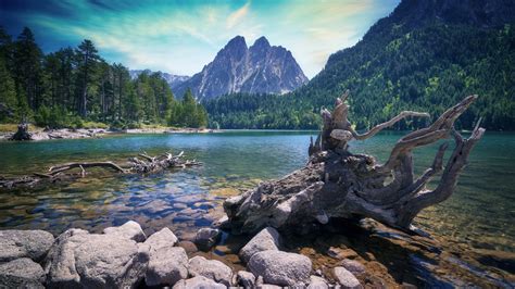 Lake With Clear Water And Stones In Background Of Mountain
