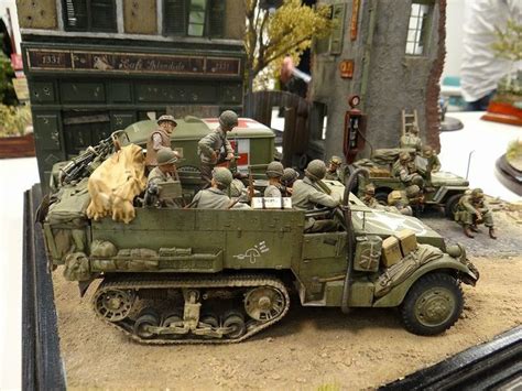 An Army Vehicle With People In It On A Table Next To Other Vehicles And