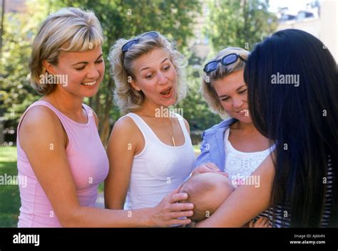 Three Women Admiring Newborn Baby In Mother S Arms Stock Photo Alamy