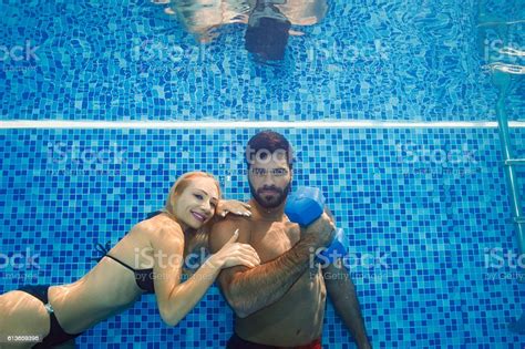 Underwater Women And Men Training With Dumbbells In Swimming Pool Stock