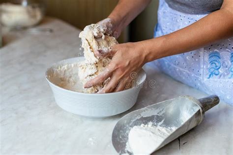 Hands Of A Young Woman Kneading Dough To Make Bread Or Pizza At Home