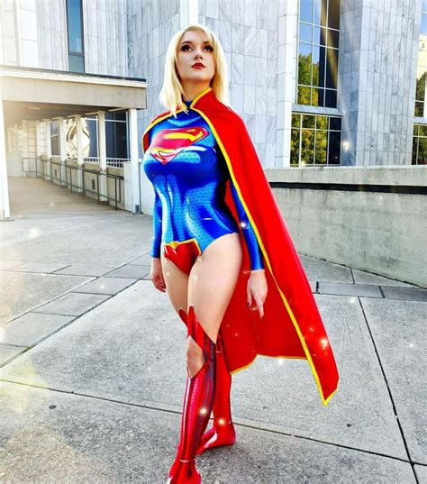 a woman dressed as a supergirl posing in front of a building