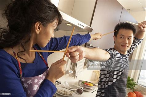 A Young Couple Play Fight With Chopsticks In The Kitchen Photo Getty