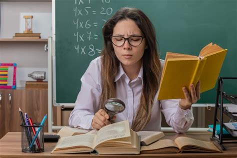 Free Photo Young Woman Teacher Wearing Glasses Looking At Book