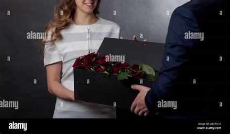 Man Gives Red Roses In An Original Box To His Beloved Woman Stock Photo