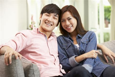 Junge Chinesische Paar Entspannen Auf Sofa Zu Hause Lizenzfreies Foto Bildagentur
