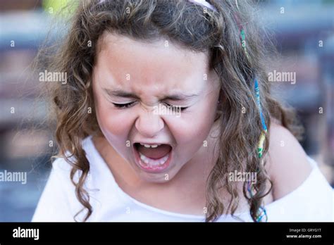 Portrait Of Curly Haired Girl Screaming Out Loud With Eyes Closed Stock