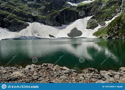 High Mountain Lake With Turquoise Water Close Up Against The Backdrop