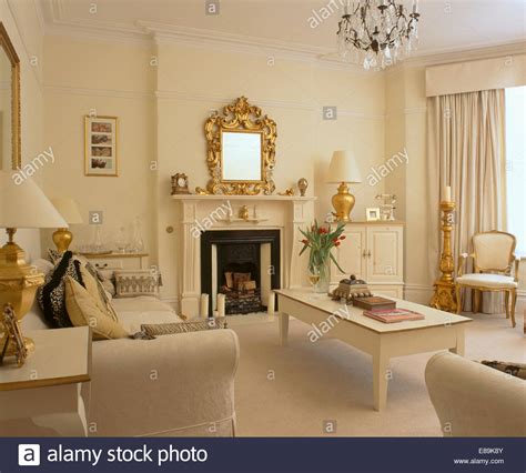 Then use fabrics on furniture and pillows or an area rug to pick up the color around the room. Cream living room with cream table and sofas and gold accessories Stock Photo - Alamy