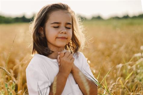 Little Girl Closed Her Eyes Praying In A Field Wheat Hands Folded In