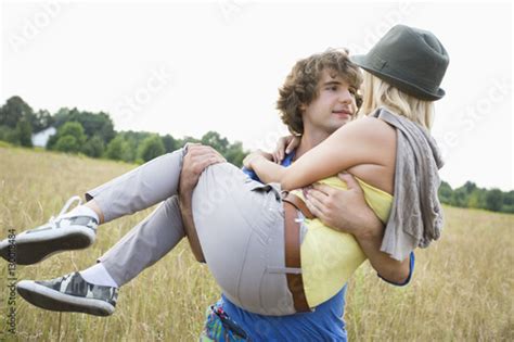 Romantic Man Carrying Woman In Field Stock Foto Adobe Stock