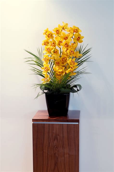 A Stunning Arrangement Of Yellow Cymbidium Orchids With Palm Leaves And Rolled Aspedistra Leaves