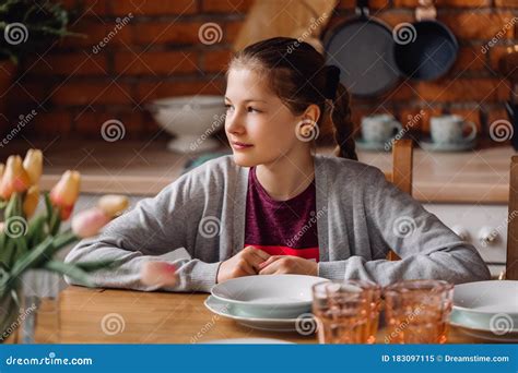 Adolescente Sentada En La Mesa De La Cocina Cocina Tipo Loft Con Paredes De Ladrillo Y Nevera