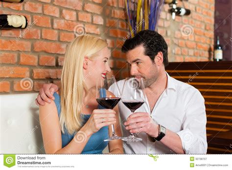 Attractive Couple Drinking Red Wine In Restaurant Or Bar Stock Image