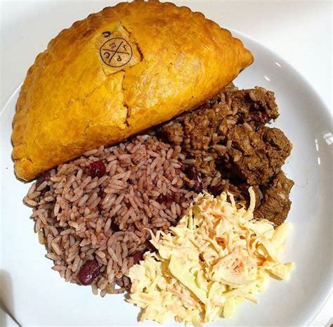 A White Plate Topped With Rice And Meat Next To A Pastry On Top Of It