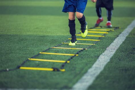 Kid Soccer Player Jogging And Spring Between Ladder Drills For Football