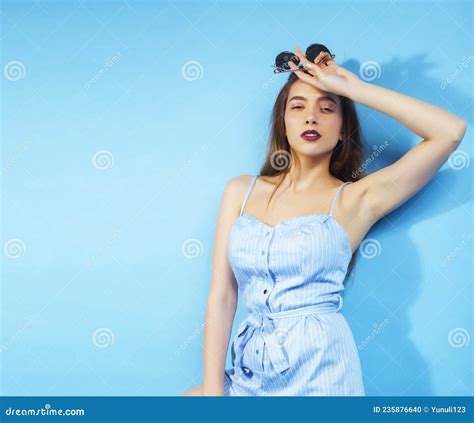 Young Pretty Girl In Sunglasses Posing Happy Smiling On Blue Background